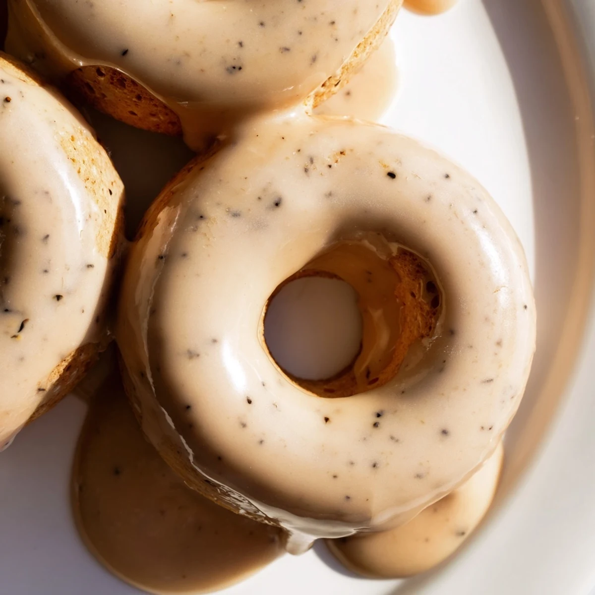 Golden glazed Earl Grey mochi donuts arranged on a white wire rack, showing their signature ring shape