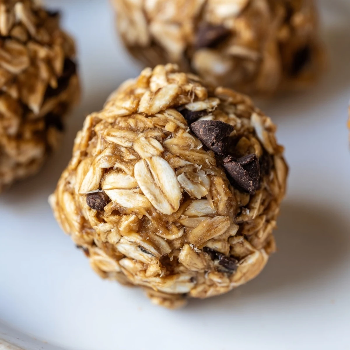 Chewy oat and peanut butter energy bites arranged on a white serving platter for easy snacking