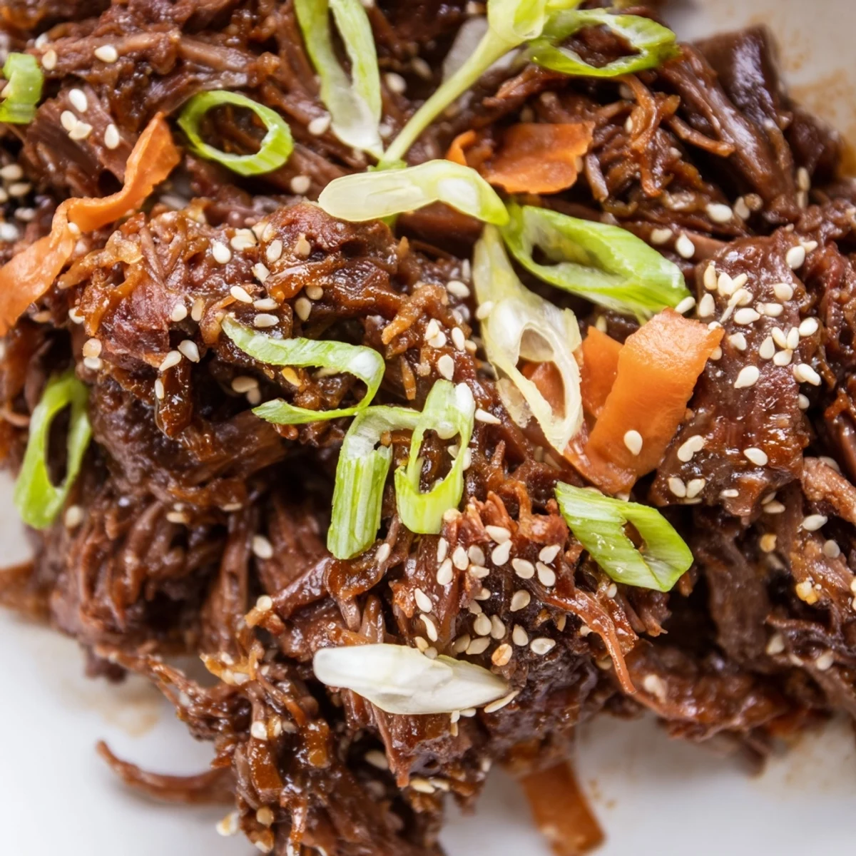 Garnished Korean style pot roast featuring sesame seeds and scallions over meltingly tender beef