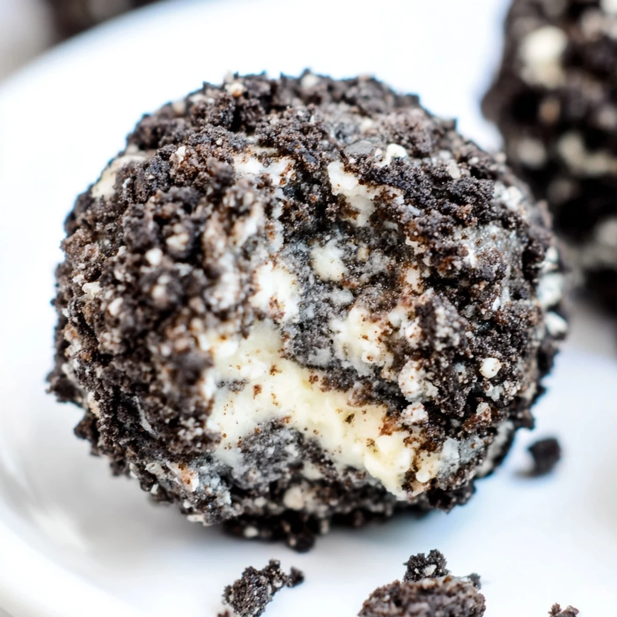 No-bake Cream Cheese Oreo Protein Balls topped with mini chocolate chips on parchment-lined tray