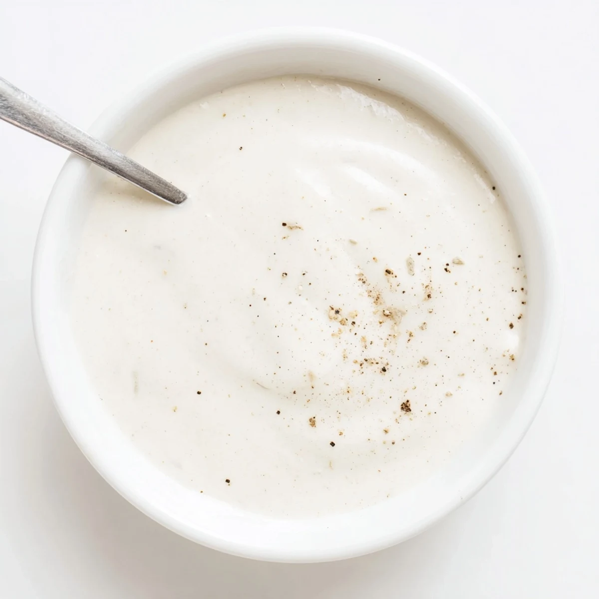 Tangy white sauce dolloped beside juicy chicken shawarma wraps with fresh lettuce and tomato toppings