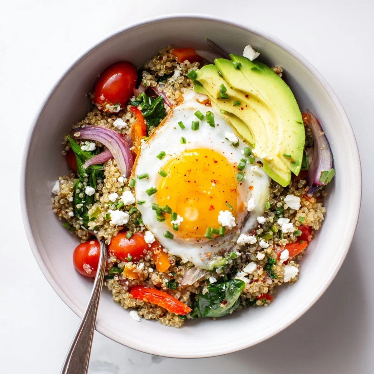 Hearty savory quinoa breakfast bowl featuring spinach, bell peppers, and perfectly cooked egg