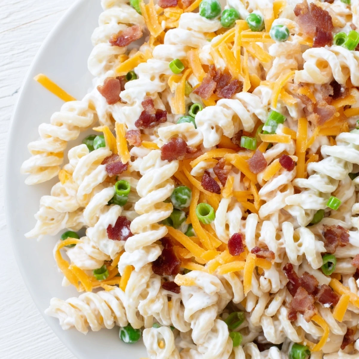 Close-up of addictive crack pasta salad showcasing rotini noodles coated in rich ranch and topped with crumbled bacon