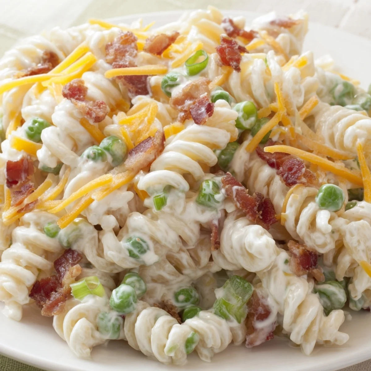 Cold crack pasta salad with tender pasta, sharp cheddar, green onions, and peas ready for a summer cookout