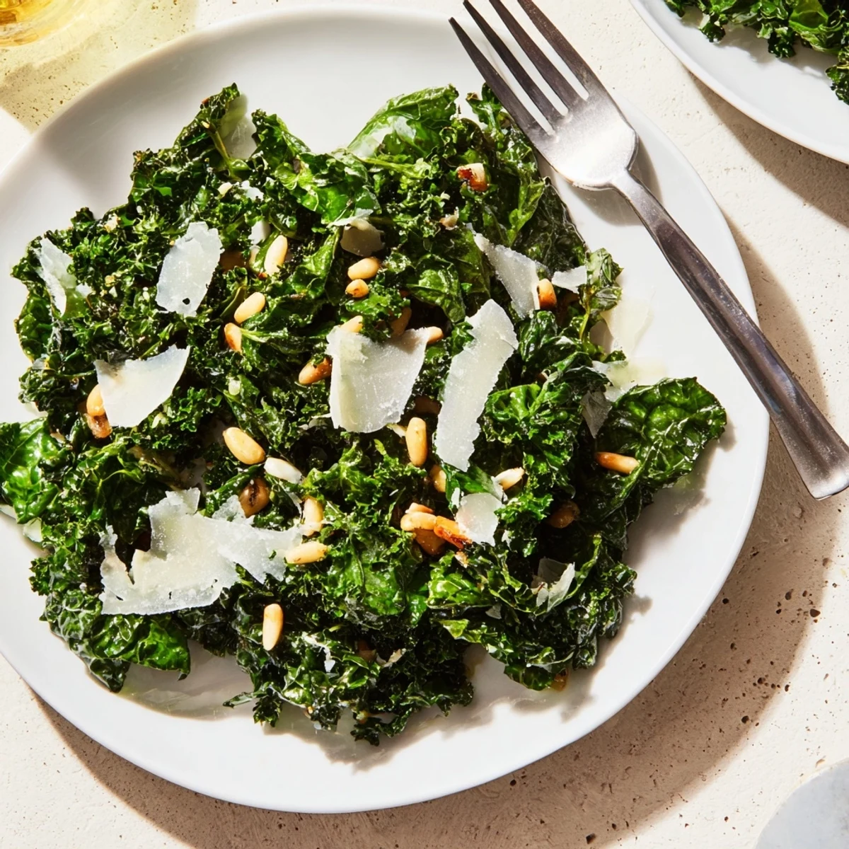 Bright garlic lemon Parmesan kale salad tossed in zesty vinaigrette on a rustic plate