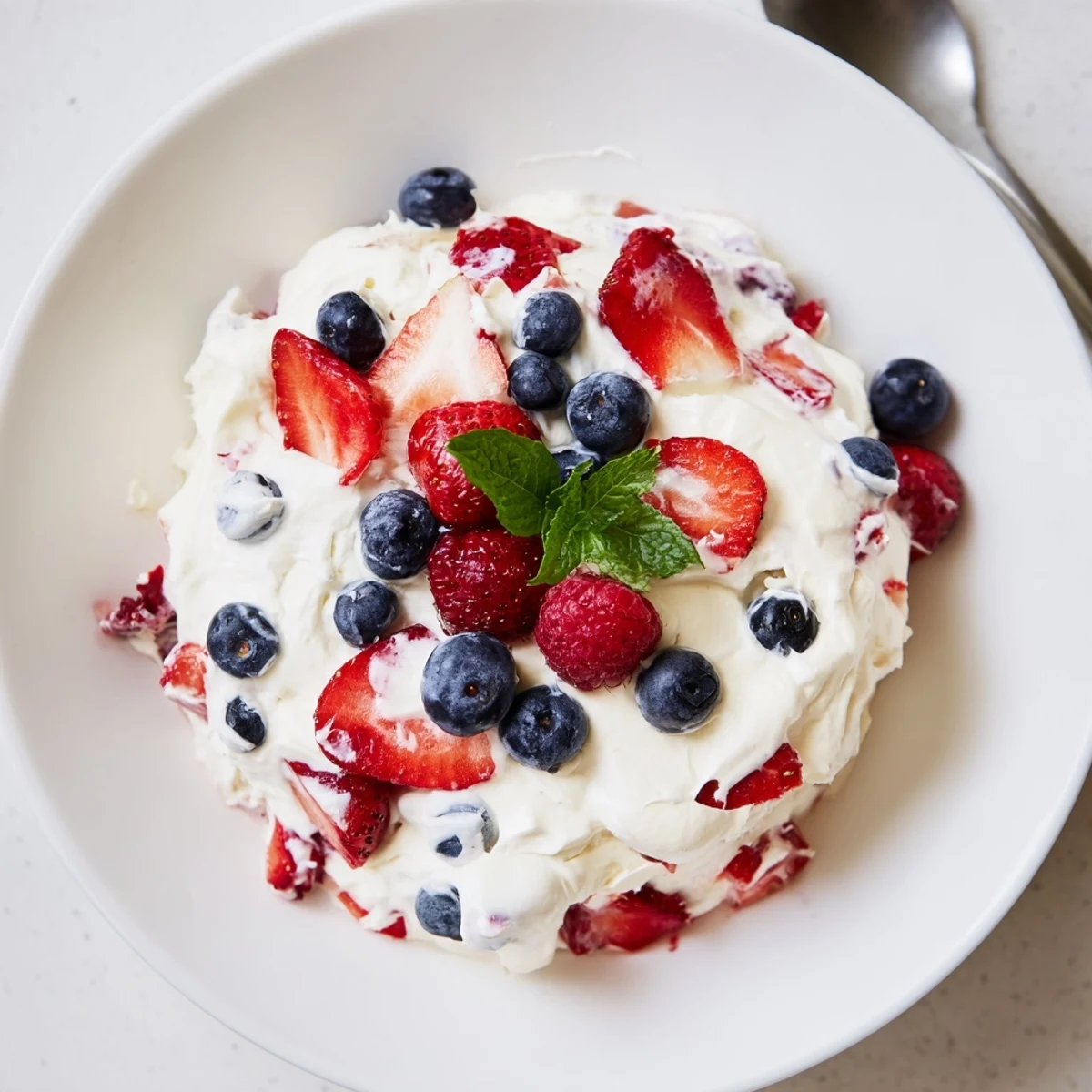 Chilled Red White Blue Cheesecake Salad with juicy strawberries, blueberries, light whipped texture