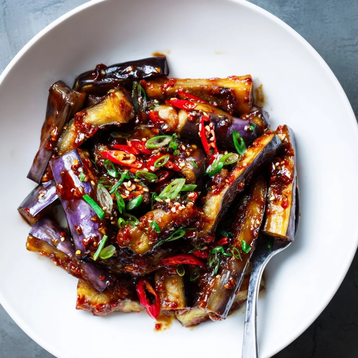 Sichuan Style Braised Aubergines glistening in spicy red sauce over rice