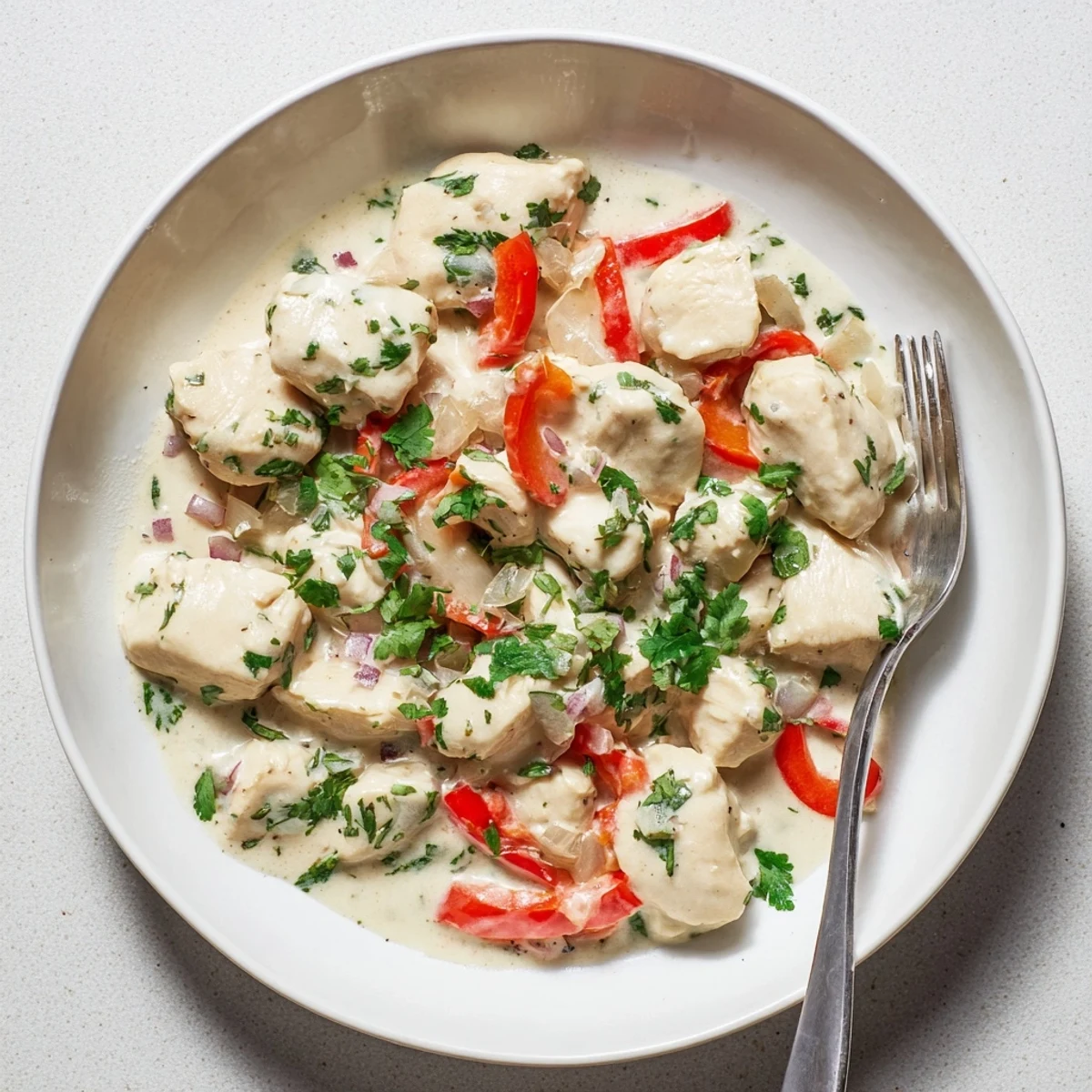 Golden Brazilian coconut chicken simmered with colorful bell peppers and fresh green cilantro garnish