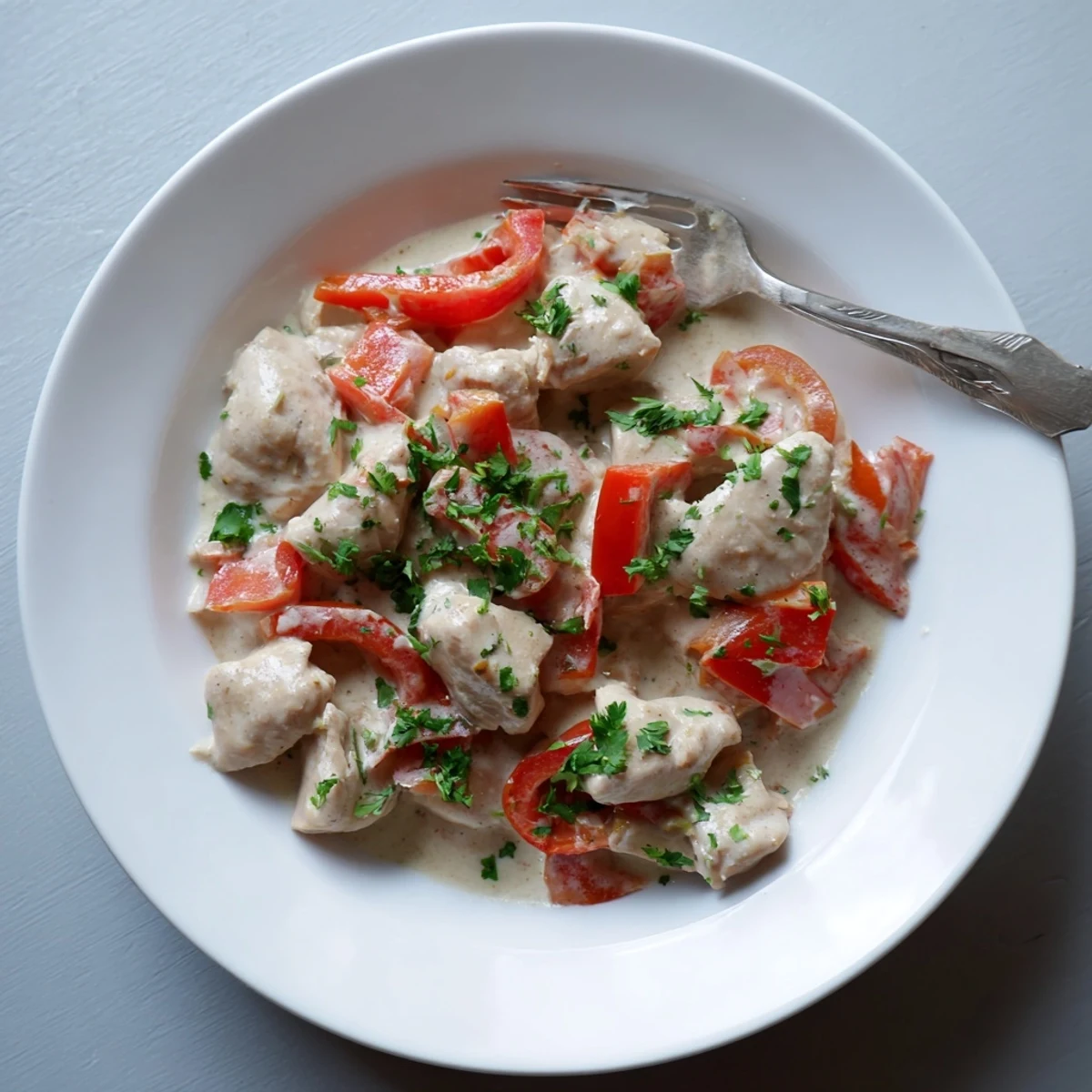 Vibrant Brazilian coconut chicken served in white bowl alongside fluffy steamed white rice