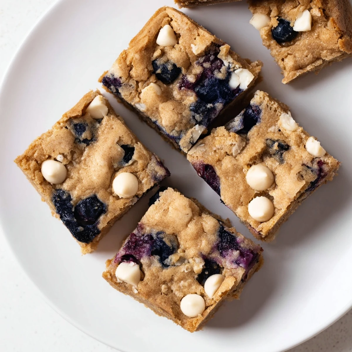 Golden blueberry blondies with bursts of juicy fruit nestled in a soft vanilla dessert bar