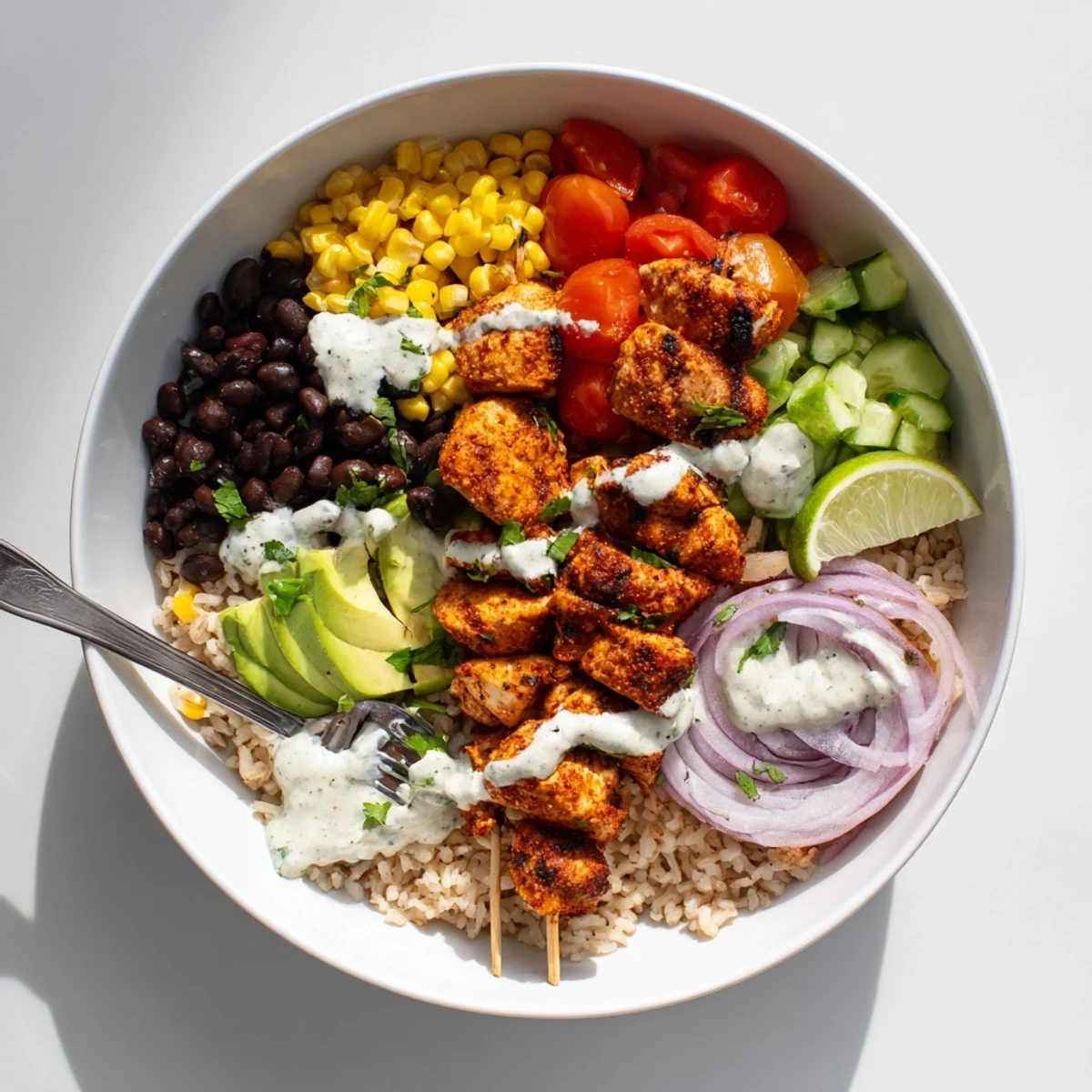 Family-style Smoky Chicken Skewer Bowl Recipe topped with zesty yogurt sauce, cilantro