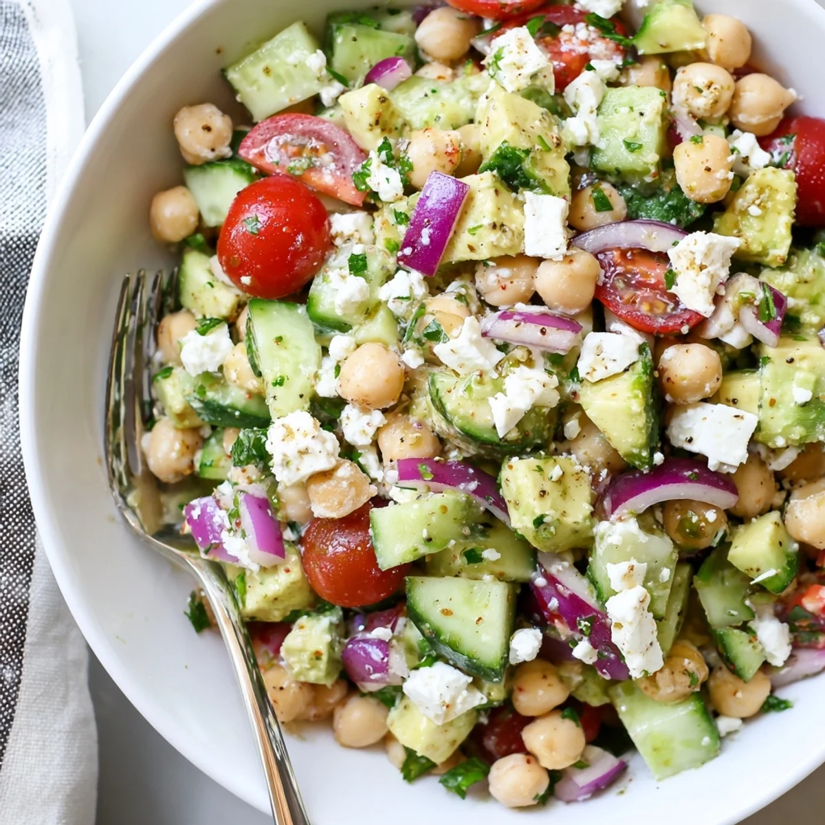 Creamy chickpea feta avocado salad tossed with fresh tomatoes and herbs